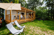 Gezellige Cottage Next Midi-lodge bij Papillon Country Resort met houten terras, relaxstoelen en fietsen.