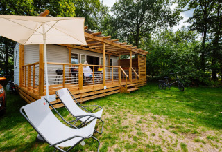 Charmant Cottage Next Midi au Papillon Country Resort avec terrasse en bois, transats et vélos à l’extérieur.