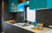 Moderne keuken in Freed Home lodge, Papillon Country Resort, Nederland, met blauwe en zwarte kastjes.