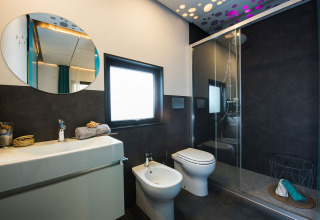 Baño moderno en Freed Home del Papillon Country Resort, Países Bajos, con ducha y bidé elegante.