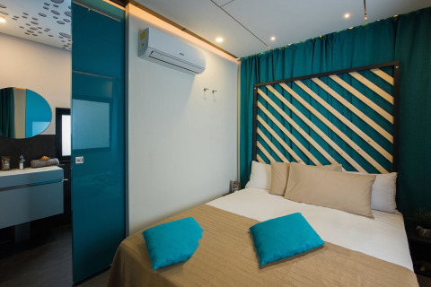 Chambre moderne à Freed Home, Papillon Country Resort, Pays-Bas, avec rideaux turquoise et lit confortable.