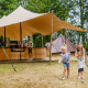 To børn leger med kugler foran en Glamptent GT-lodge ved BreeBronne feriepark i Holland.