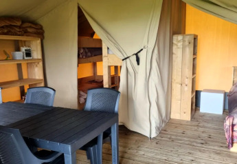 Indvendig udsigt over en safari-telt på Boerderijcamping de Hinde i Holland med spisebord og senge.