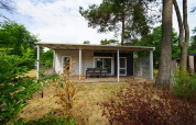 Gezellige glamping accommodatie in een moderne chalet, omringd door natuur, bomen en buiteneethoek.