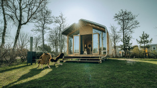 Casa natura Wikkelhouse Bear nel parco vacanze De Klepperstee, Paesi Bassi, tra alberi e luce solare.