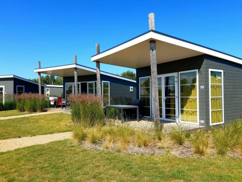 Casa pequeña moderna Comfort Lodge en Kompas Camping Nieuwpoort en Bélgica, en un día soleado con cielo azul.