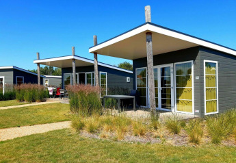 Casa pequeña moderna Comfort Lodge en Kompas Camping Nieuwpoort en Bélgica, en un día soleado con cielo azul.