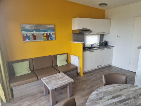 Moderne zithoek met keuken in Comfort Lodge bij Kompas Camping Nieuwpoort, België, honden toegestaan.