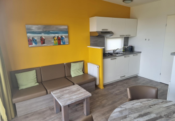 Salon moderne avec coin cuisine au Comfort Lodge de Kompas Camping Nieuwpoort, Belgique, chiens acceptés.
