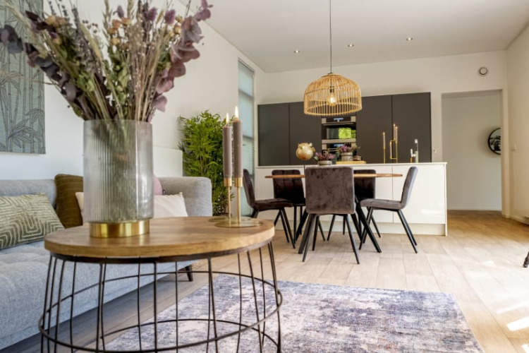 Acogedora sala-comedor de cabaña con muebles modernos, mesa de comedor y lámpara decorativa.