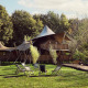 Luksuriøs glamping telt Hacienda ved Resort de Parel i Holland, omgivet af grønne træer og afslapningsstole.