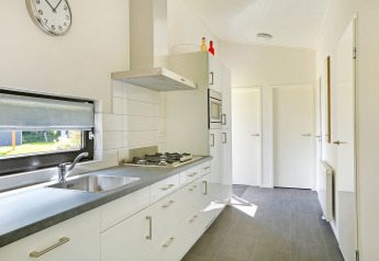 Moderne, lichte keuken in Lodge Grand Modern op Holiday Park De Lochemse Berg, Nederland, met groot raam.