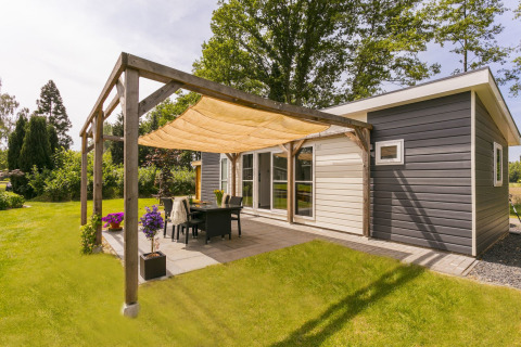 Zonnig terras bij Lodge Mistique in Holiday Park De Lochemse Berg, Nederland, met moderne inrichting.