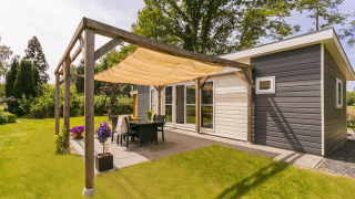 Terraza soleada en Lodge Mistique, Holiday Park De Lochemse Berg, Países Bajos, con decoración moderna.
