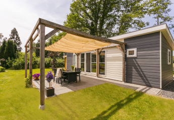 Zonnig terras bij Lodge Mistique in Holiday Park De Lochemse Berg, Nederland, met moderne inrichting.