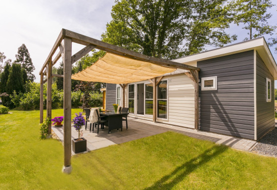 Patio soleggiato al Lodge Mistique presso Holiday Park De Lochemse Berg, Paesi Bassi, con arredo moderno.