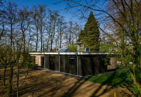 Contemporary Nature House lodge at Buitengoed Ruysbos, Netherlands, surrounded by peaceful woodland scenery.