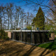 Moderne lodge, Nature House, omgivet af træer i Buitengoed Ruysbos, Holland, på en solrig forårsdag.