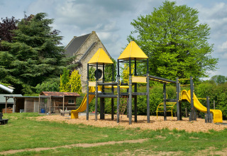 Buitenspeeltuin met gele glijbanen en klimtoestellen bij Camping La Dolce Vita in Limburg, Nederland.