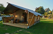 Safari tent with sanitary facilities at Camping La Dolce Vita in the Netherlands, set on a grassy field.