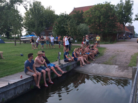 Persone che si rilassano vicino all'acqua al Camping Pasveer, un villaggio vacanze in Frisia, Paesi Bassi.