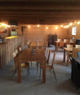 Acogedora sala común en Camping Pasveer, Friesland, Países Bajos, con mobiliario de madera y luces colgantes.