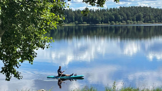 Un kayakista disfruta de un día tranquilo en el lago de Camping Falkudden, rodeado de naturaleza en Dalarna, Suecia.