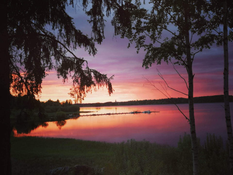 Splendido tramonto sul lago presso il Camping Falkudden holiday park a Dalarna, Svezia, tra gli alberi.