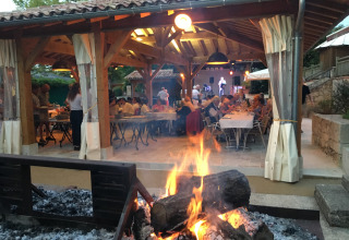 Cena all'aperto e musica dal vivo vicino al falò a Le Camp de Florence, Occitania, Francia.