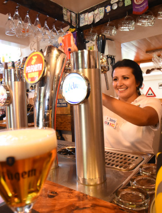 Una camarera sirve cerveza de barril en el parque vacacional Le Camp de Florence en Occitania, Francia.