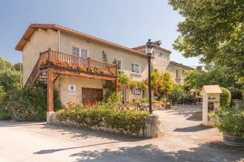 Feriepark Le Camp de Florence i Occitanie, Frankrig med blomsterpyntet balkon, terrasse og grønne omgivelser.
