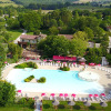 Aerial view of the pool and green landscape at Le Camp de Florence holiday park in Occitanie, France.