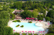 Luchtfoto van zwembad en terras op Le Camp de Florence vakantiepark in Occitanië, Frankrijk, in groene omgeving.