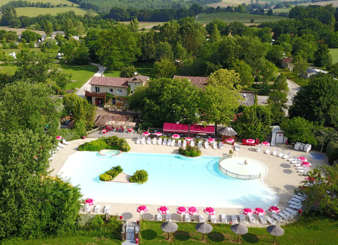 Luftaufnahme des Pools und der Liegewiese im Ferienpark Le Camp de Florence, Occitanie, Frankreich.