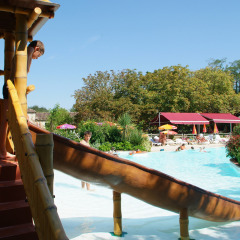 Niños juegan en un tobogán junto a la piscina en el parque vacacional Le Camp de Florence en Occitania, Francia.