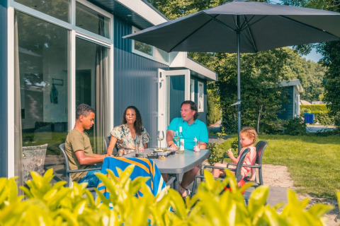 Gezin in achtertuin van accommodatie - EuroParcs De Biesbosch - Dordrecht, Zuid-Holland, Nederland
