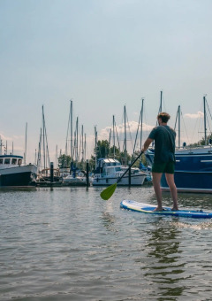 SUP mit Booten im Hintergrund - EuroParcs De Biesbosch - Dordrecht, Südholland, Niederlande