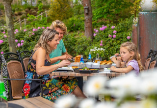 Family outside at the table - EuroParcs Maasduinen - Belfeld, Limburg, Netherlands