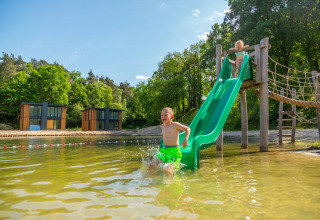 Boy off water slide in recreational lake - EuroParcs Maasduinen - Belfeld, Limburg, Netherlands