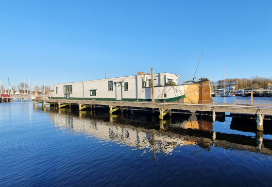 Husbaaden Houseboat De Zwerver ligger ved Marina Parcs Naarden i Nederlandene på en solrig dag.