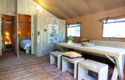 Interior of a modern lodge with wooden furniture, large table, cozy seating and natural window light.