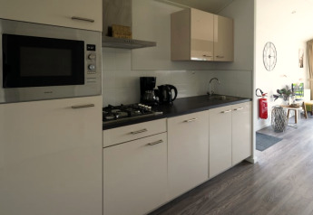 Keuken in een moderne lodge met fornuis, microgolfoven, koffiezet en uitzicht op leefruimte.