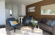 Lodge living room with modern accents, comfortable chairs, a gray sofa, and natural light from windows.