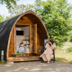 En kvinde og et barn nyder det udendørs foran en Trekkerspod-lodge i Kampeerdorp de Zandstuve, Holland.