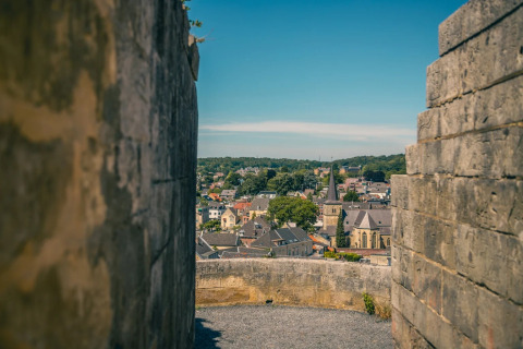 View of a charming town through stone walls at a glamping holiday park on a bright sunny day.