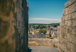 View of a charming town through stone walls at a glamping holiday park on a bright sunny day.
