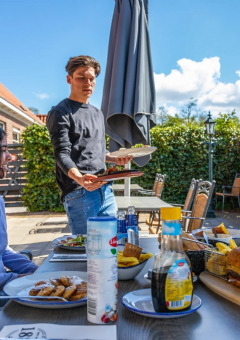 Grupo de personas disfruta de una comida al aire libre en un parque vacacional con alojamiento glamping.