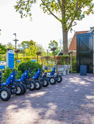 Foto de un parque vacacional con glamping, karts estacionados frente al vestíbulo y vegetación.
