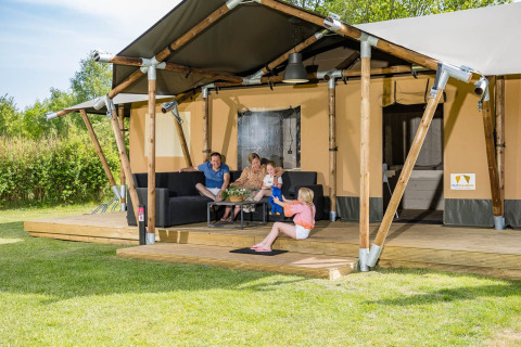 Una familia se relaja afuera de una tienda safari Stuuflodge en Kampeerdorp de Zandstuve, Países Bajos.