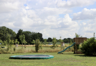 Speelplein met trampoline en glijbaan bij Camping de Heerlijkheid Vorenseinde, Noord-Brabant, Nederland.